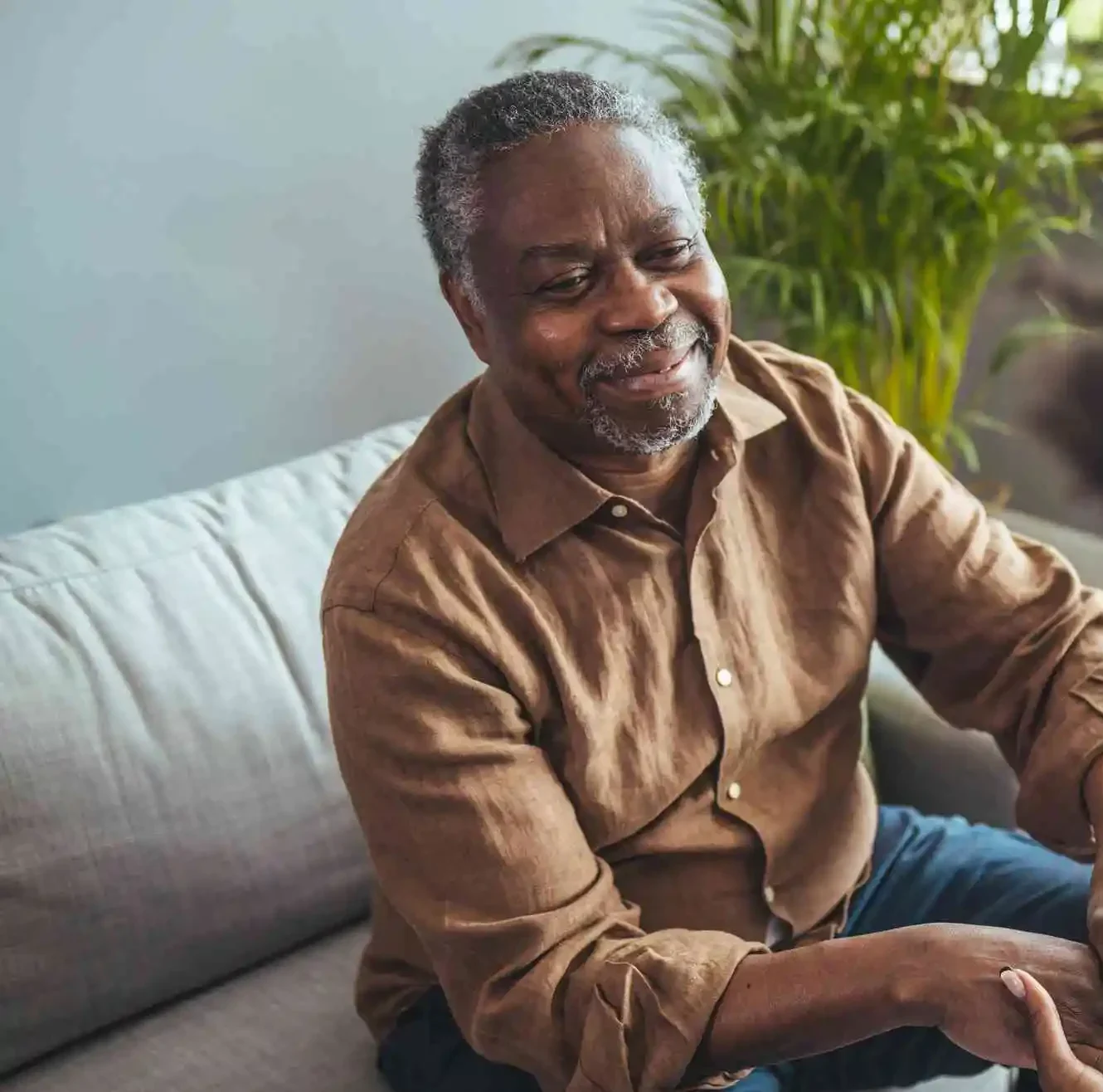 A mid-adult black nurse attends to a senior black man at home, providing medical care and support, ensuring his comfort in a familiar environment.