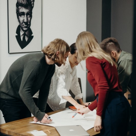 A group of people looking at papers on a table