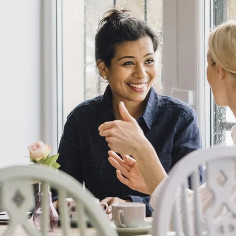 2 women at a table talking
