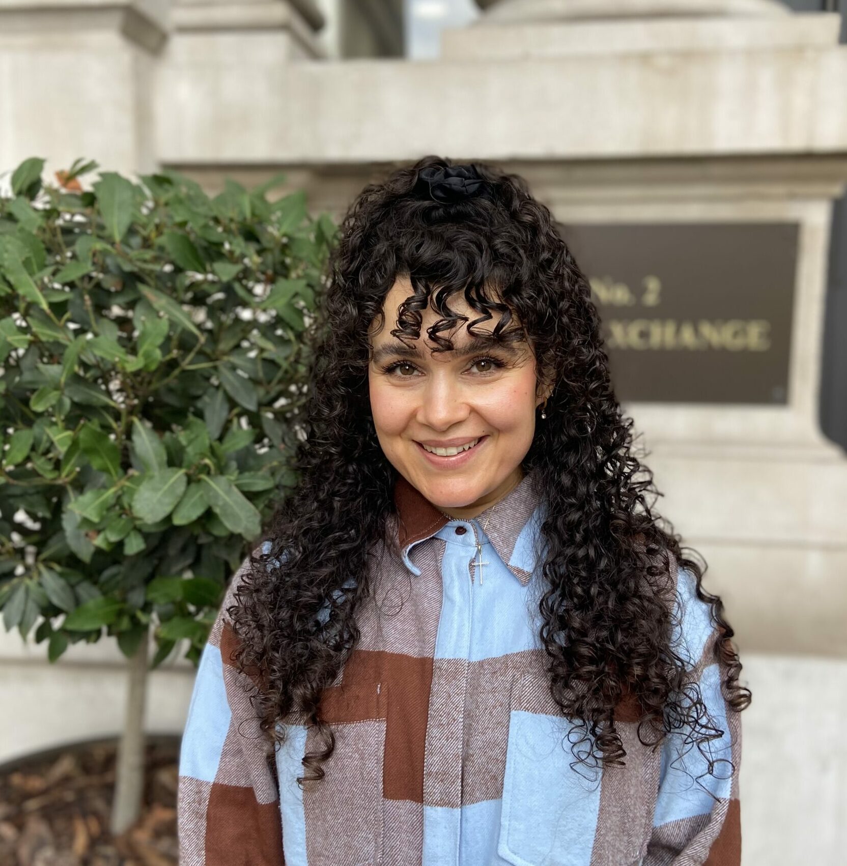 A person with curly hair smiling