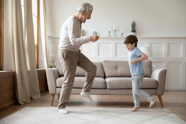 A person and child dancing in a living room