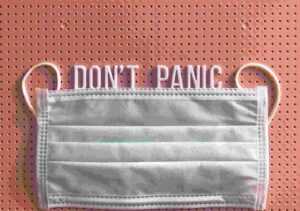 surgical mask put over writing saying 'don't panic'