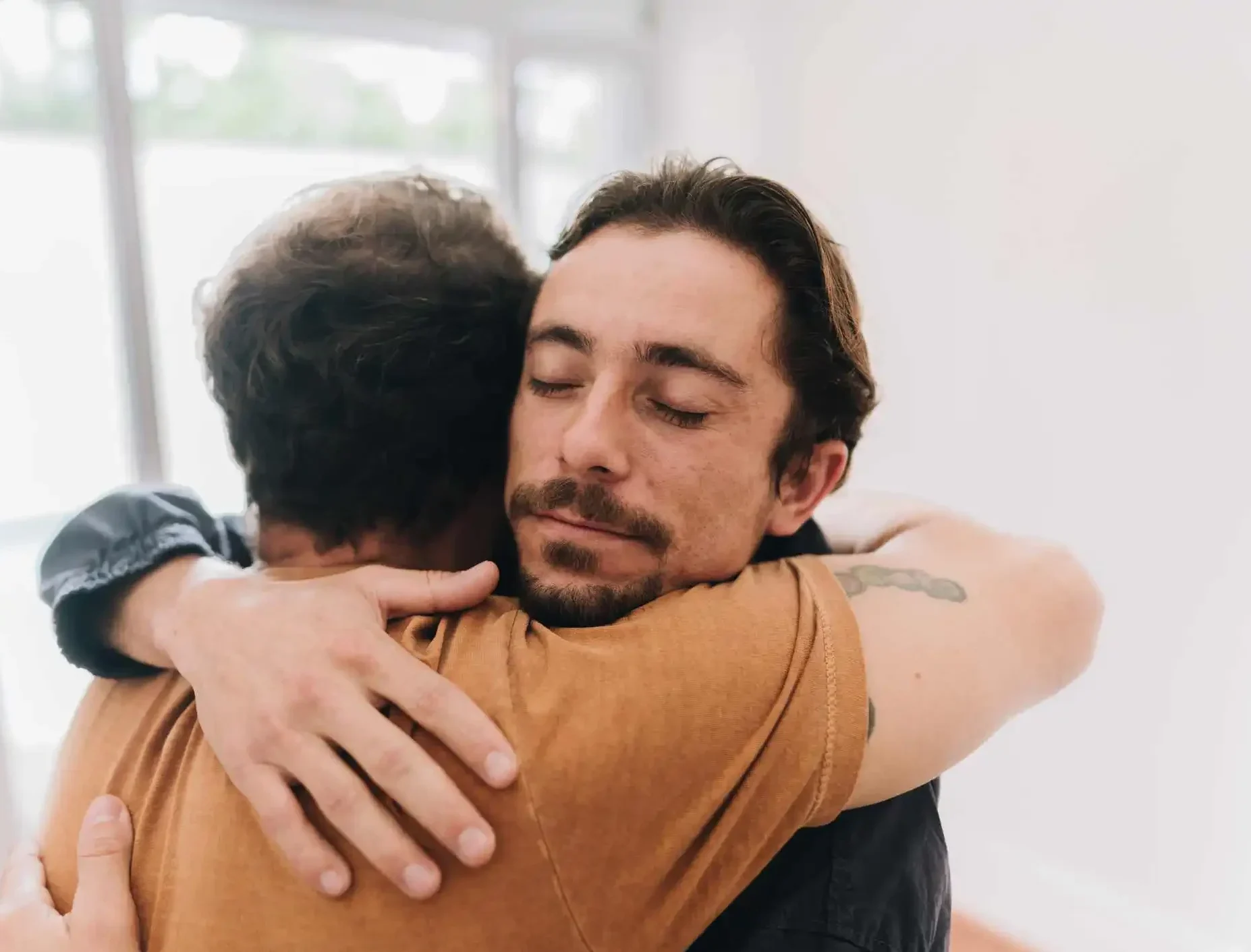 Father and son embracing at home